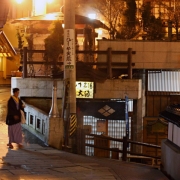 Japonijos Alpės. Šibu. Moteris eina į viešają maudyklą, kurioje teka gydančių savybių turintis vanduo iš karštosios versmės