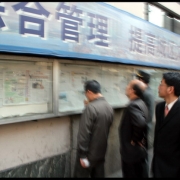 Kinija, Šanchajus. Praeiviai skaito laikraščius gatvėse